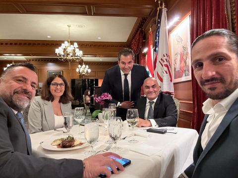Dinner table in a formal dining room with U.S., Lebanese and LAB-C flags