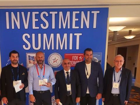 Five delegates in front of the Investment Summit backdrop