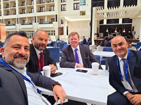 Four men seated in a hotel atrium