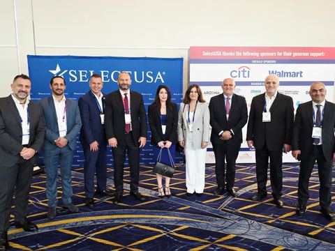 Nine delegates in front of the SelectUSA sponsor backdrop