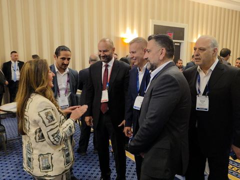 Delegates talking with an attendee in a conference room