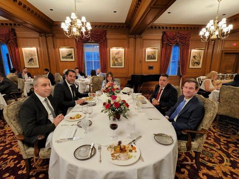 Dinner at an oval table with floral centerpieces