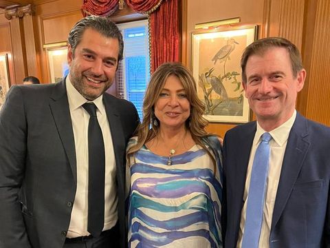Three people posing together at a reception
